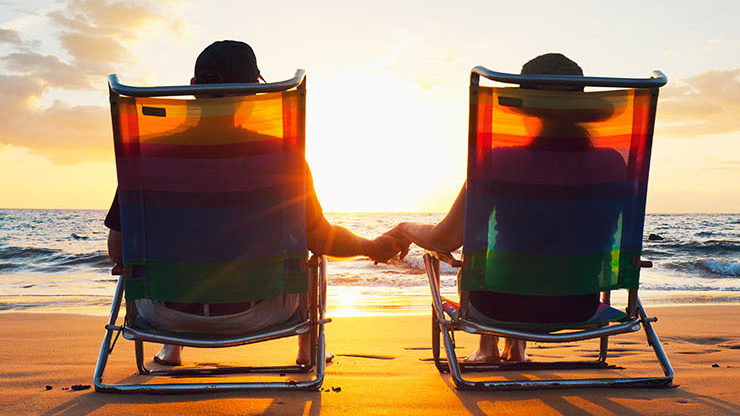 Couple Holding Hands on Lawn Chair at the Beach