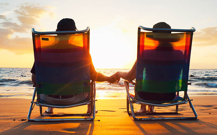 Couple Holding Hands on Lawn Chair at the Beach