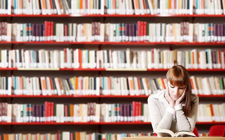 Woman reading a book in library