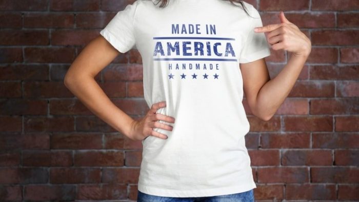 Woman in white t-shirt and jeans in front of brick wall