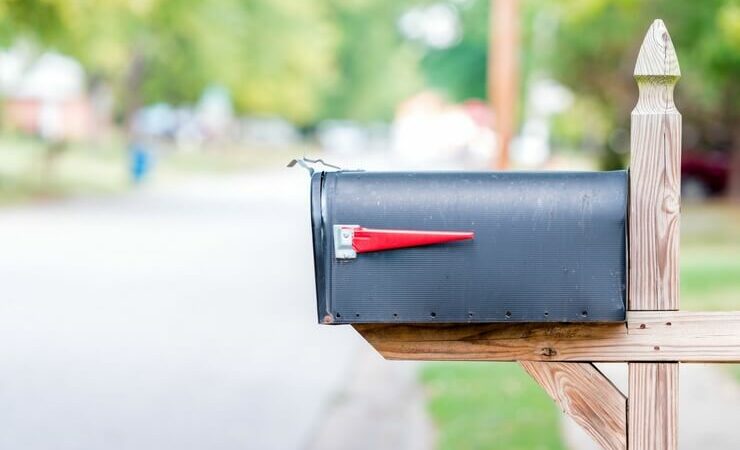 Black mailbox on wooden post FI