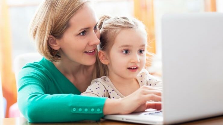 Lady with little girl working on computer FI