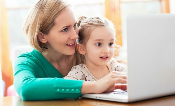 Lady with little girl working on computer FI