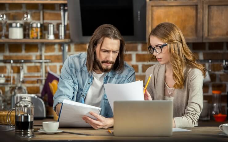 Man and woman at home budgeting at a computer FI