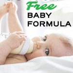 Baby holding bottle of formula