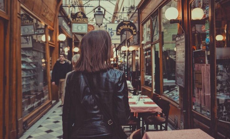 Woman walking down an alleyway shopping while wearing a leather jacket