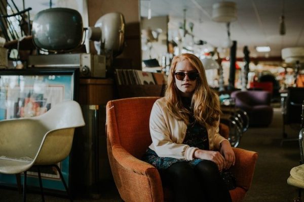 Woman sitting in a consignment store in orange chair