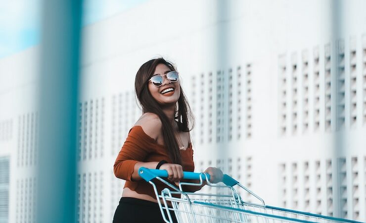 Girl with a big smile pushing a grocery cart