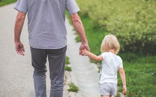 Man and little girl walking while holding hands