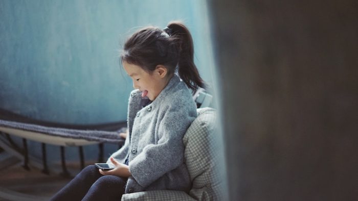 little girl learning and playing on her phone