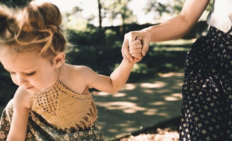 Mom and daughter playing outside while holding hands