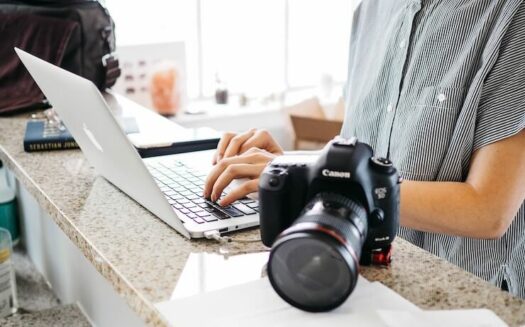 Photographer uploading images to their computer to sell online and make money