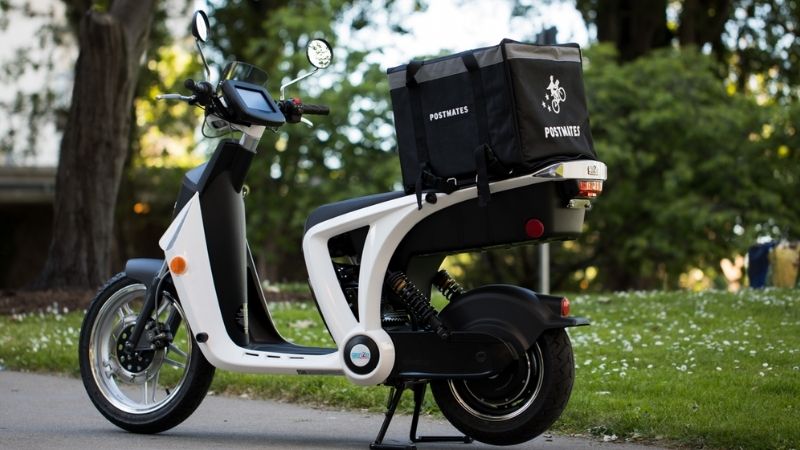 Postmates Deliveery box on the back of a white scooter