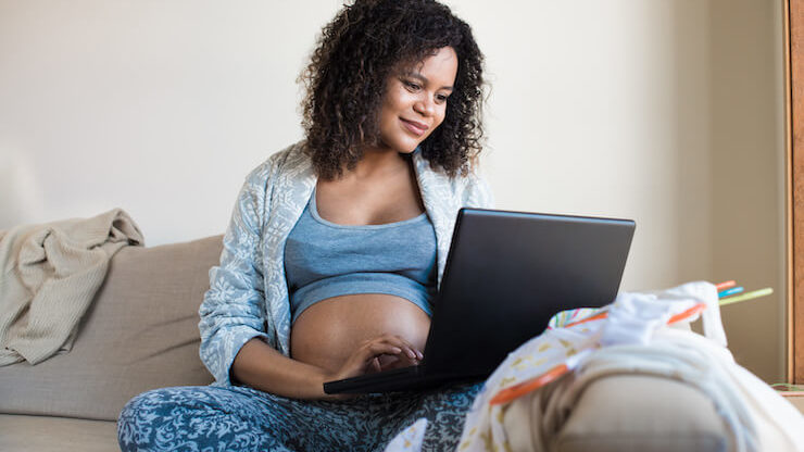 Pregnant woman shopping online registering for her baby