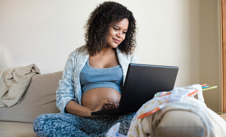 Pregnant woman shopping online registering for her baby