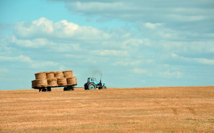 Tractor pulling hay in farmland field