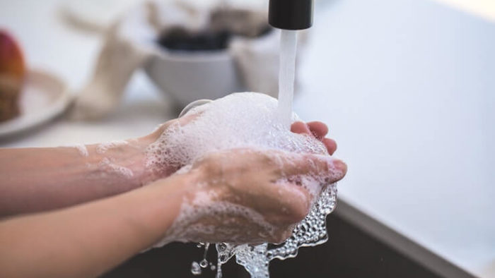 Person washing their hands with a lot of bubbles under the sink