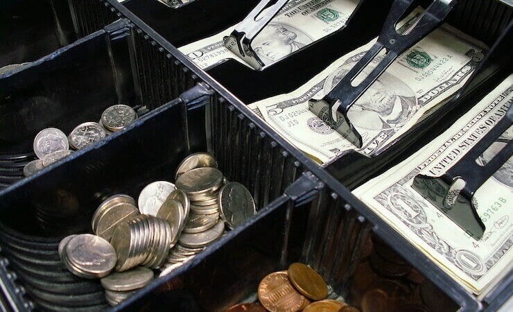Cash and coins in a register drawer of a cash register