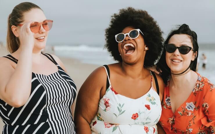 3 happy girls laughing while at the beach talking about future retirement