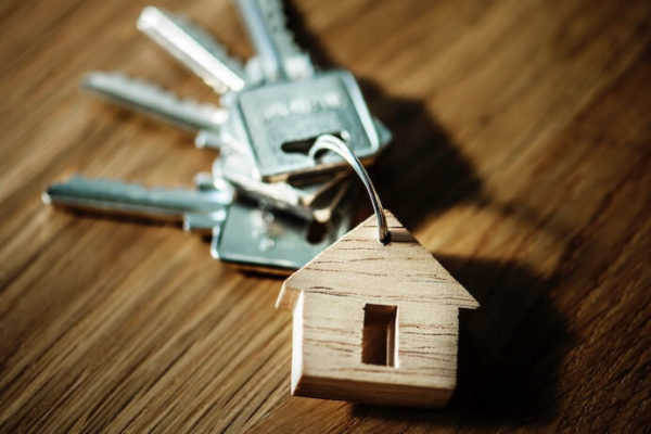 Keys for house laying on a wood table with house keychain