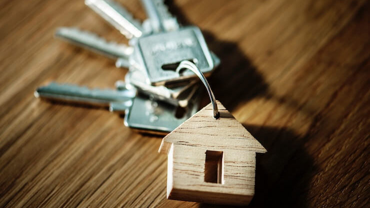 Keys for house laying on a wood table with house keychain
