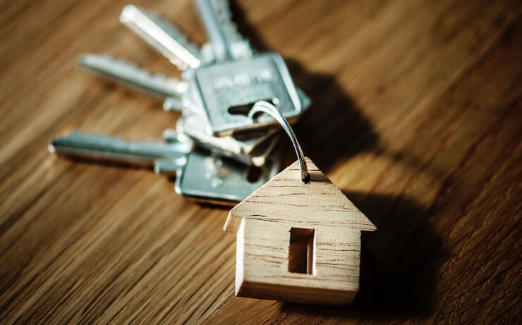 Keys for house laying on a wood table with house keychain