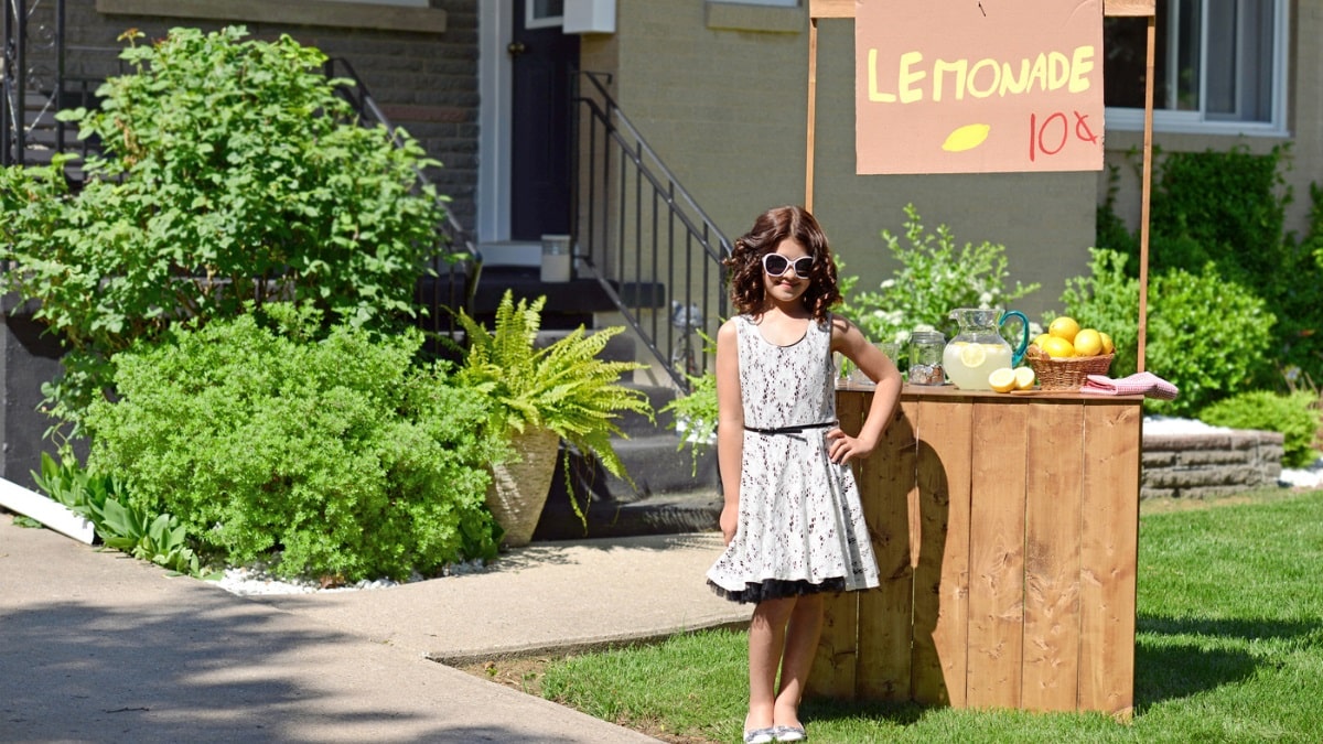 kid in front of lemonade stand