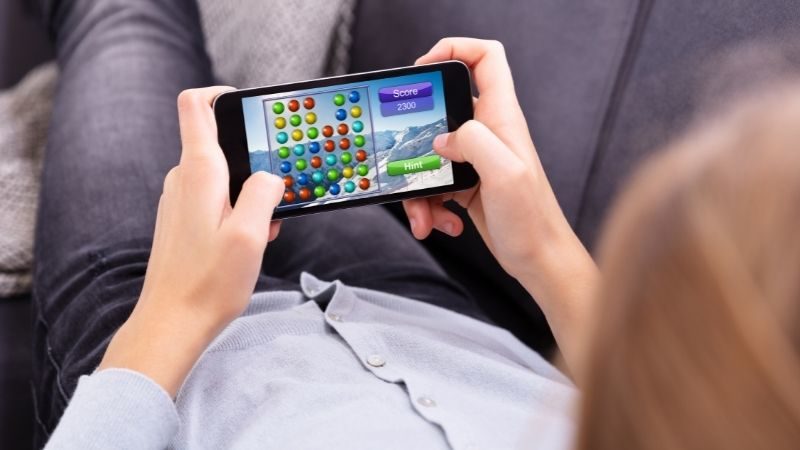 man playing game on cell phone