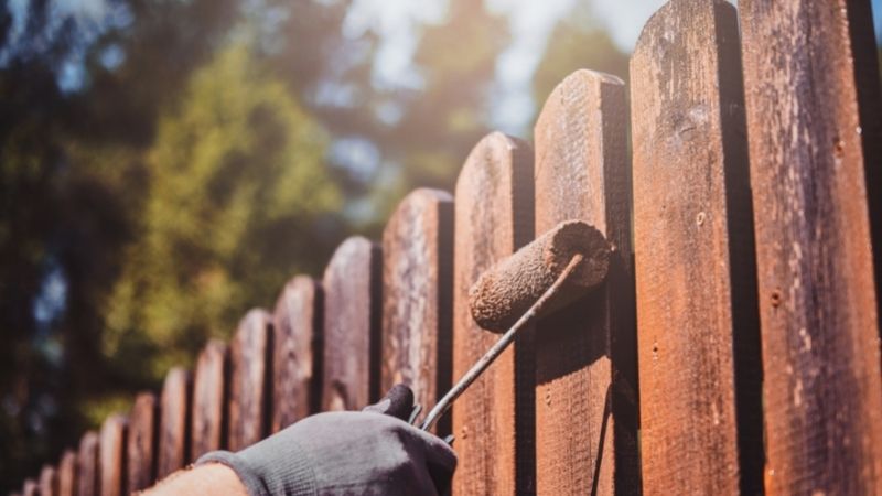 teen painting fence