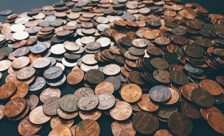 A bunch of pennies and coins spread across a table