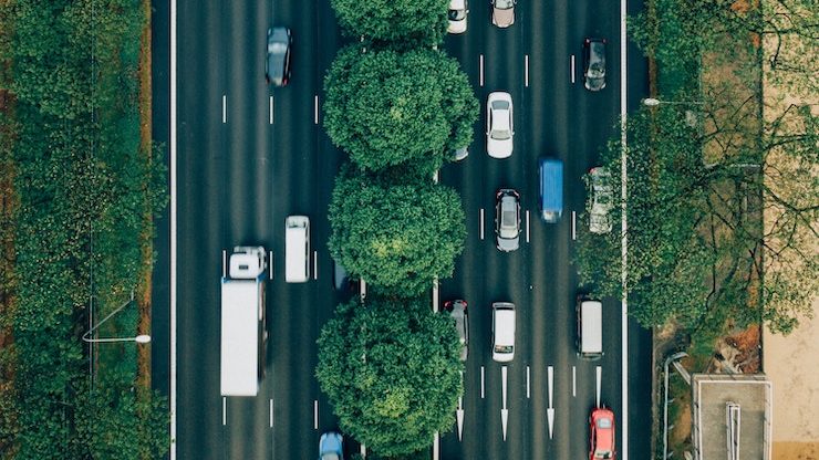 Birds eye view of cars with trees lining the road