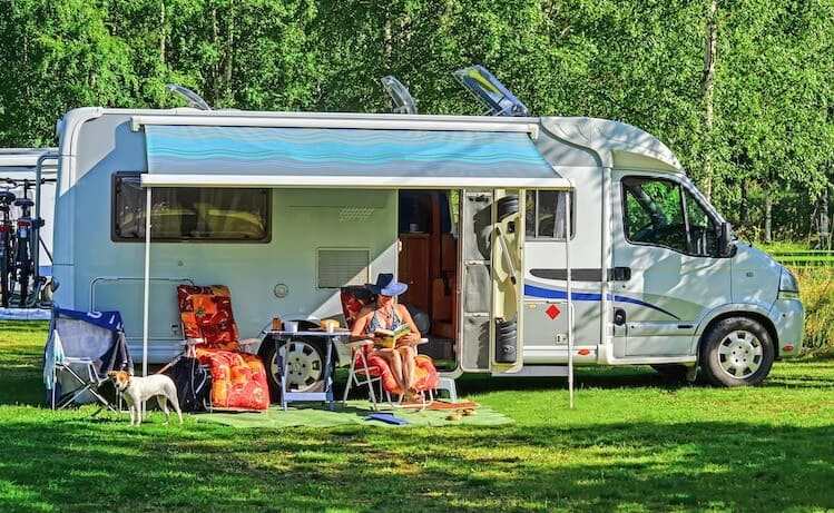 woman reading book outside RV camping