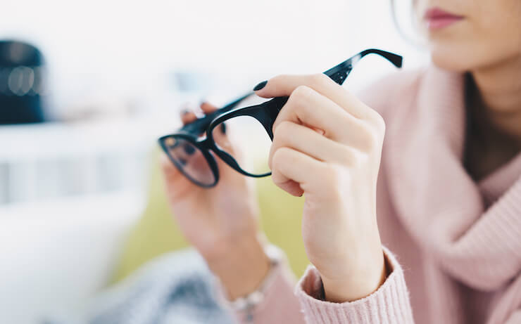 Woman looking at glasses at discount store