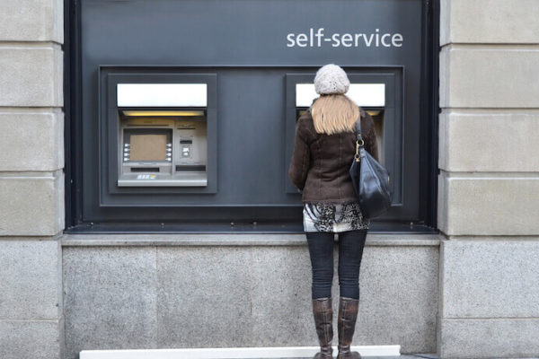 Woman using a self-service ATM machine at a bank