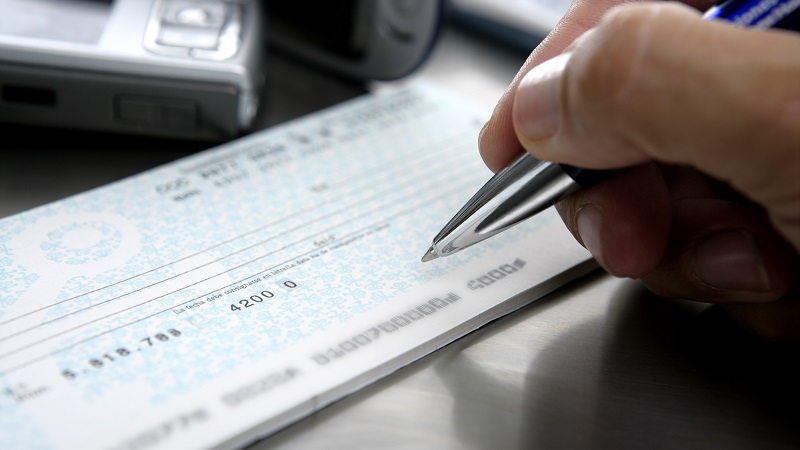 person writing a check to get money